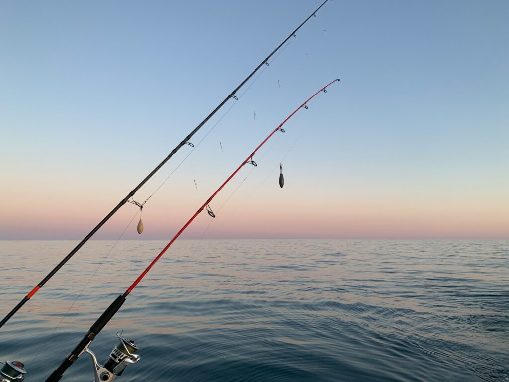 Anglers fishing from a boat on Gold Beach bay waters during summer afternoon